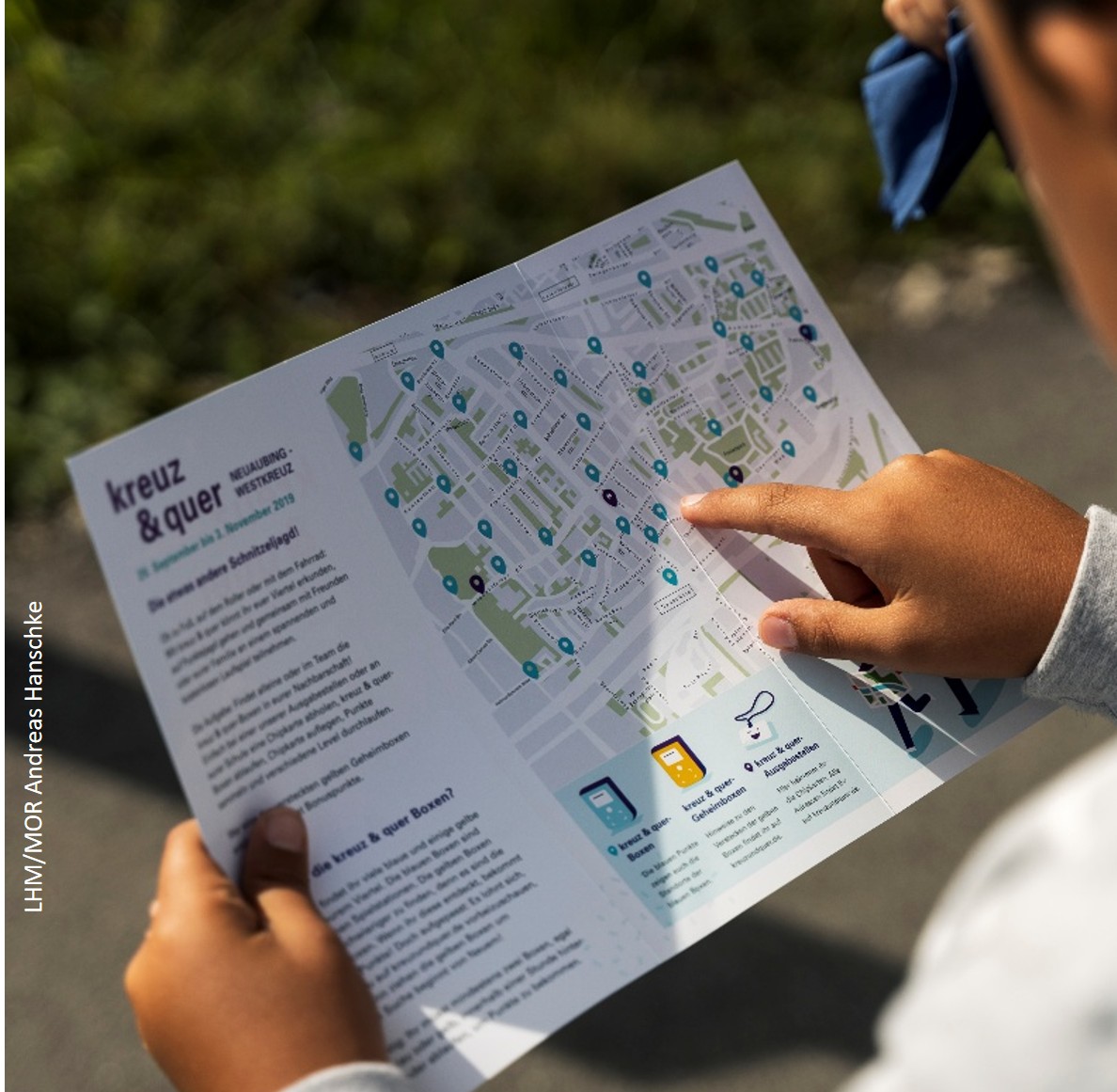 Kind zeigt auf Standortpunkt auf der kreuzundquer Flyer Karte