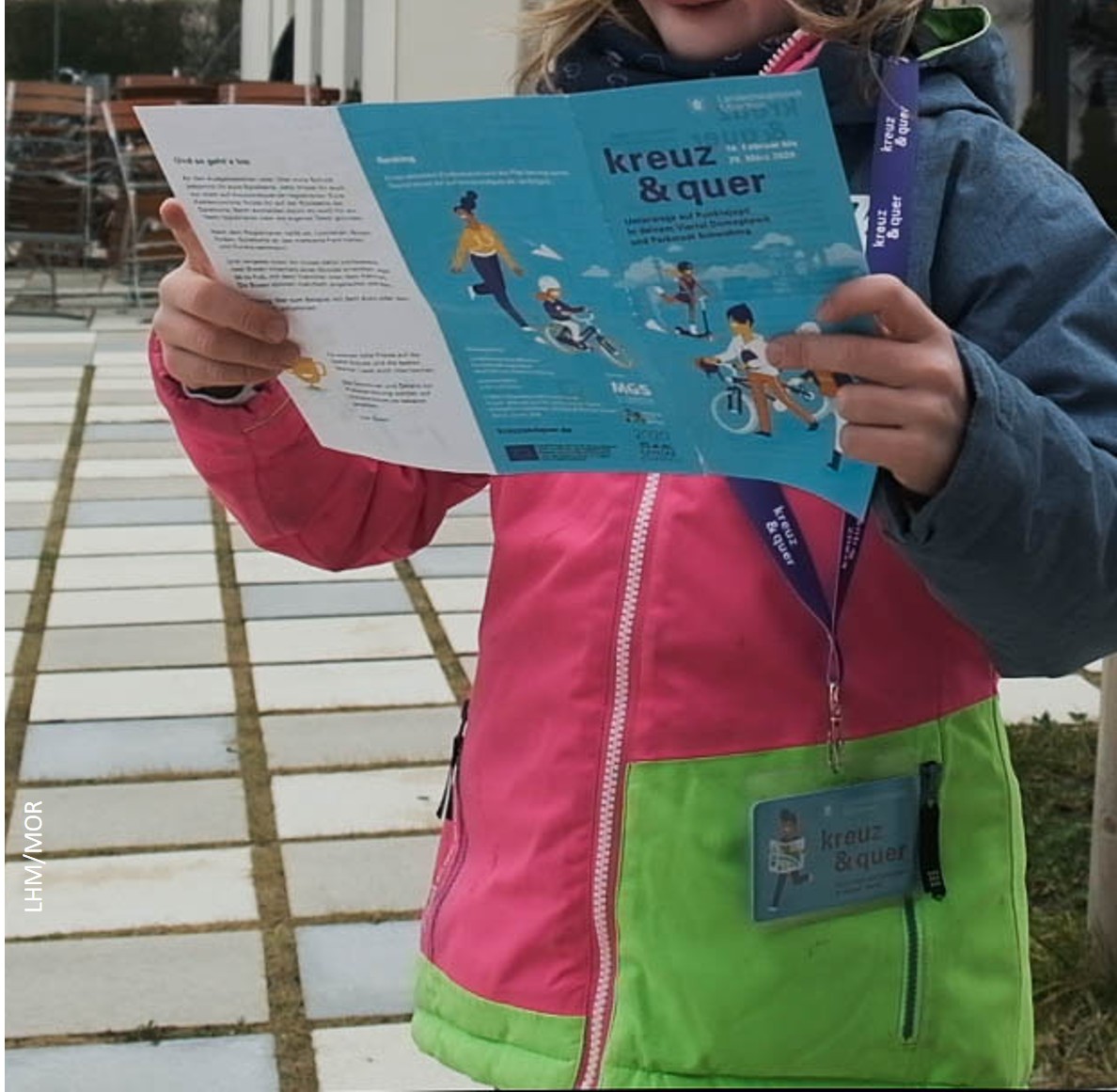 Kind mit kreuzundquer Flyer in der Hand